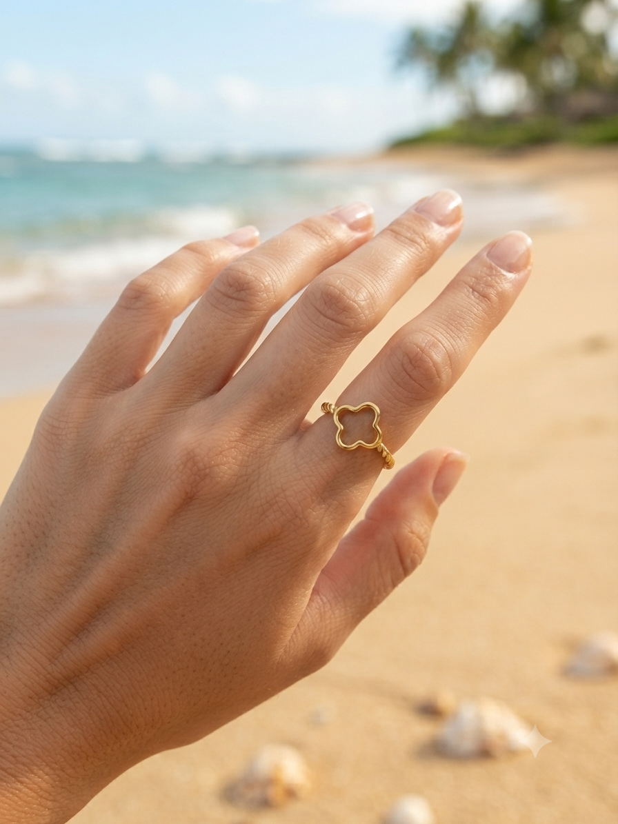 Bague Trèfle dorée ajourée portée à la main, ambiance plage