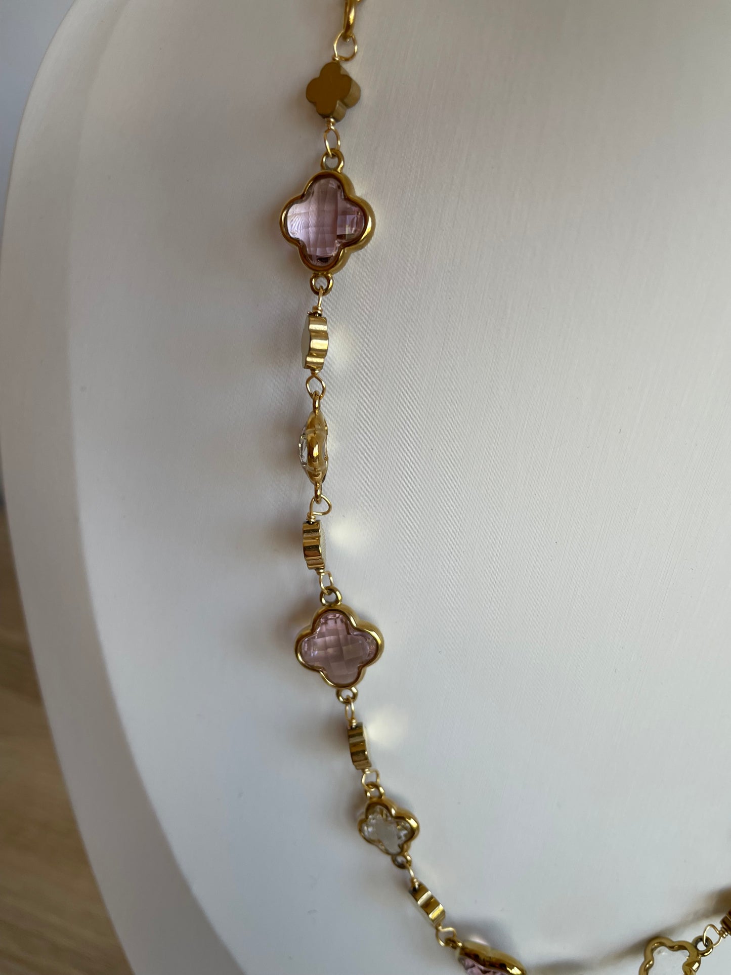 Vue rapprochée du collier Stacy rose, chaîne dorée et pierres trèfle
