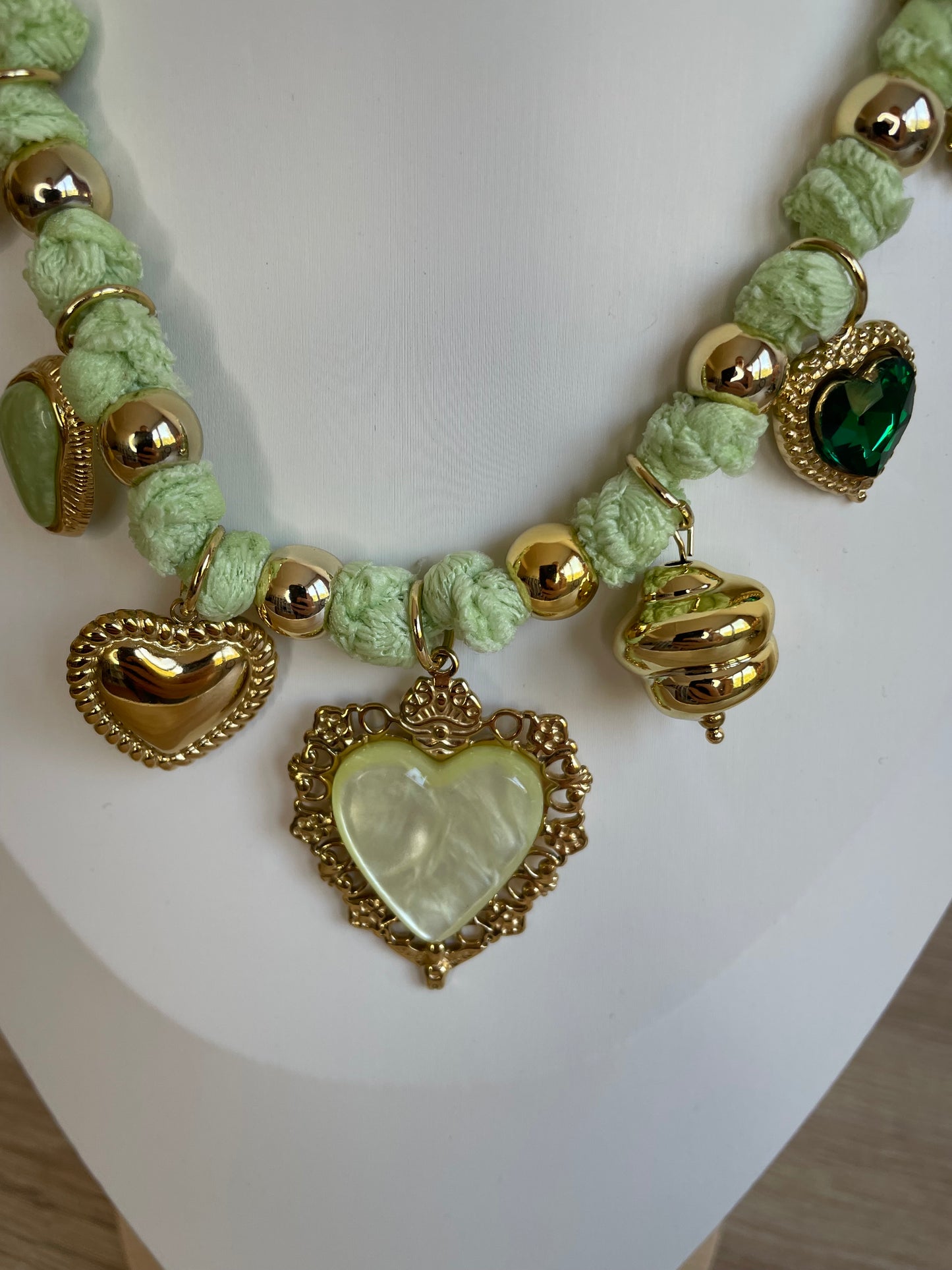 Gros plan du collier Lovéa vert avec breloques cœur en acier inoxydable et pierre verte
