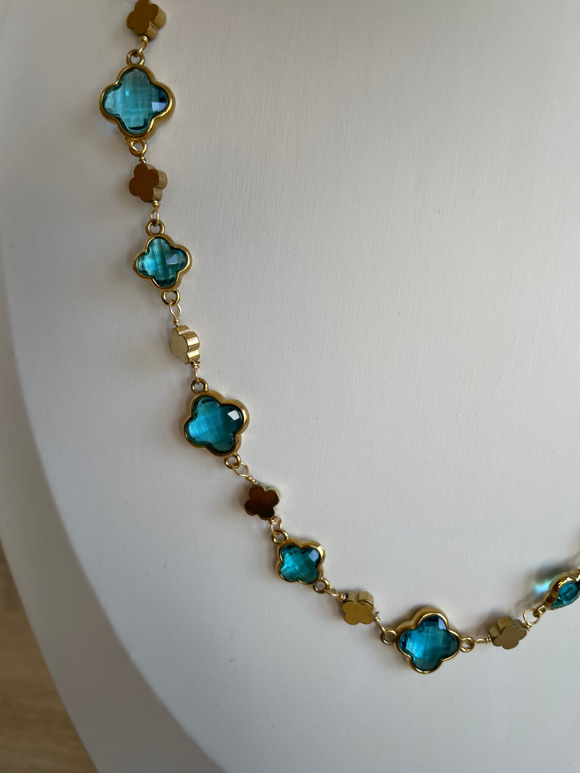 Gros plan des maillons trèfle bleus du collier Stacy en acier inoxydable