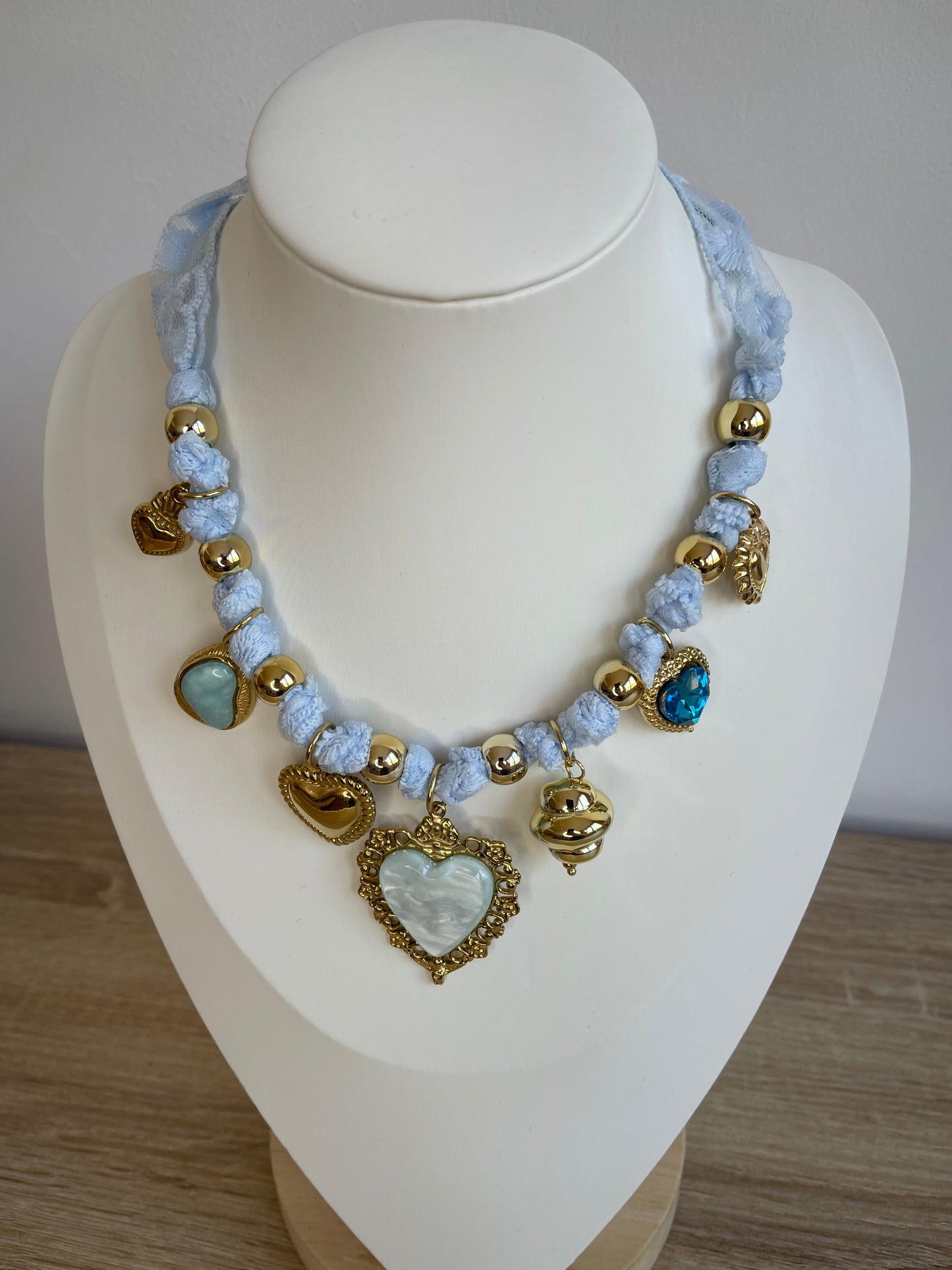 Collier Lovéa bleu porté sur buste, cordon dentelle et pendentif cœur doré