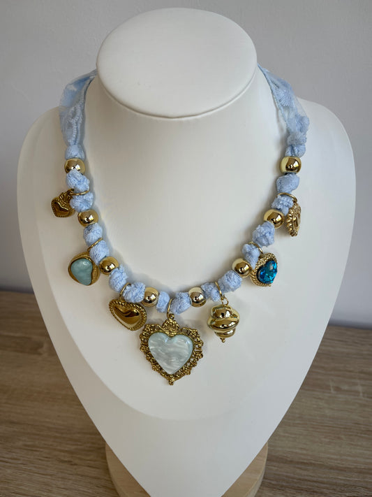 Collier Lovéa bleu porté sur buste, cordon dentelle et pendentif cœur doré