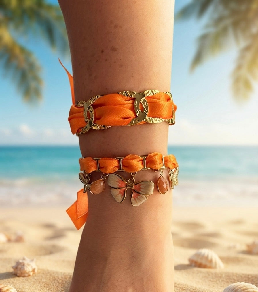 Détail des breloques du bracelet orange : papillon émaillé blanc, petit papillon bronze et pierres